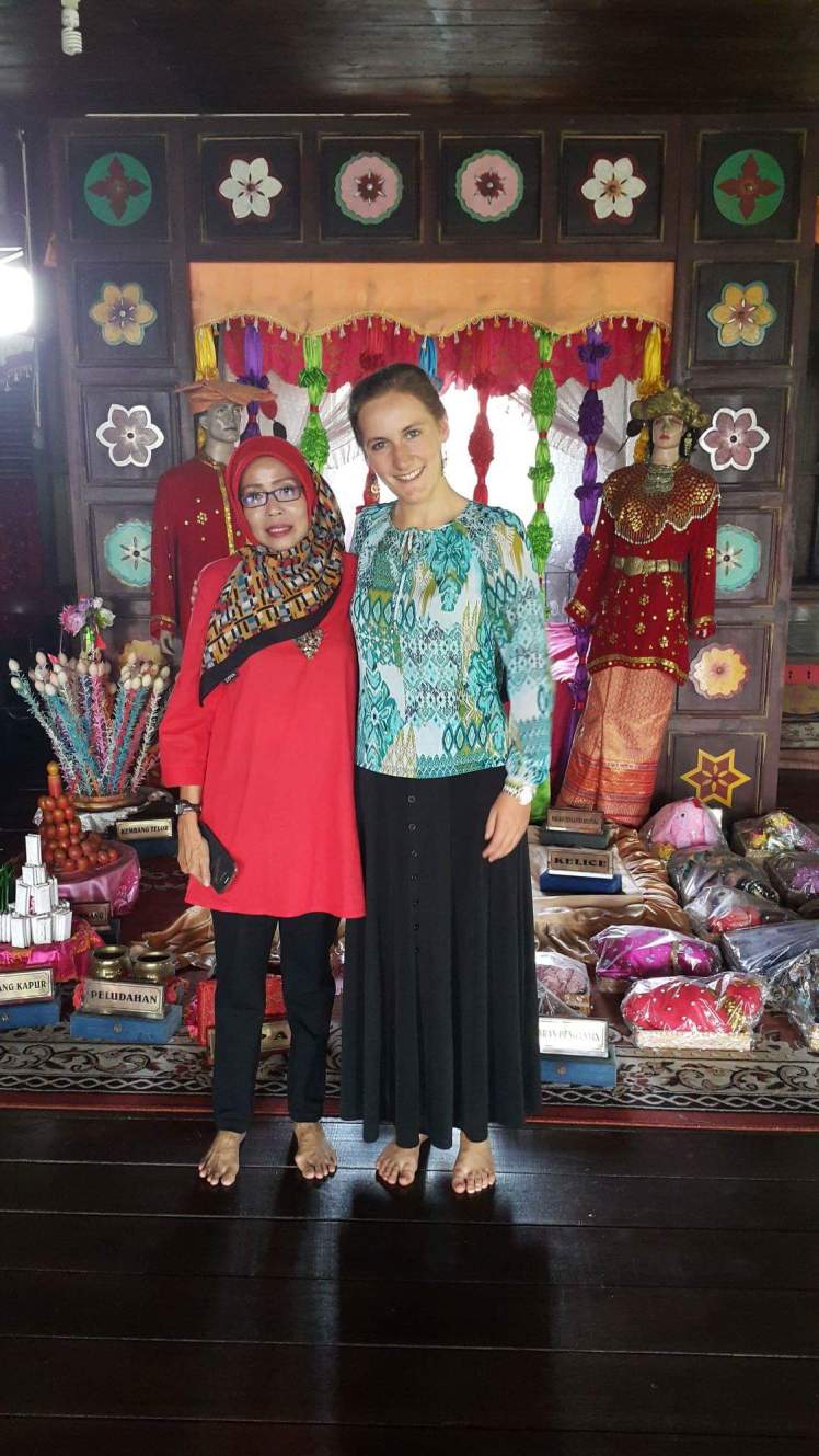 With Ibu Evi in front of an assortment of cultural artifacts in Belitung's Rumah Adat [Culture House].