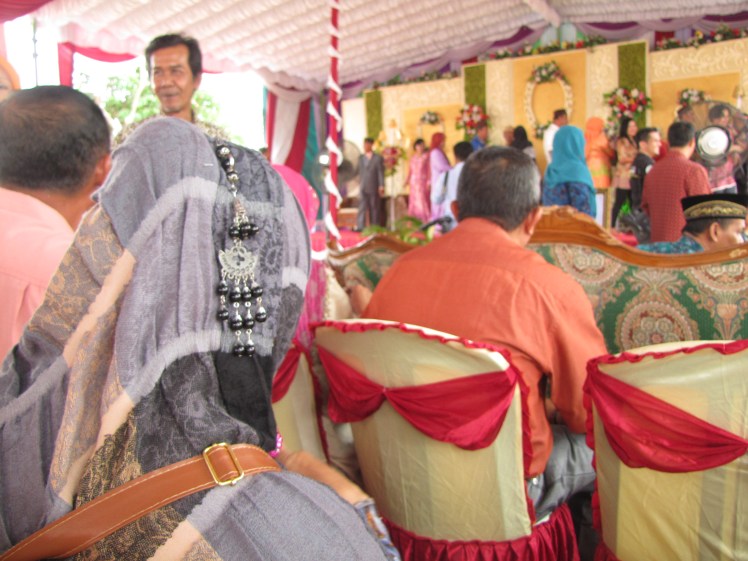 While we sit and nibble at our kue, we have prime viewing of the endless procession of greeters on stage. Indonesians get dressed up for weddings, and it is dazzling to see all of the bright colors and variety of styles on display.
