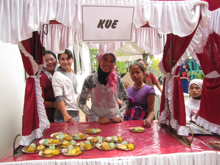 Once we have congratulated Despri and Nisa and their families, we walk of the stage and are immediately greeted by a kue [cake] stall. 