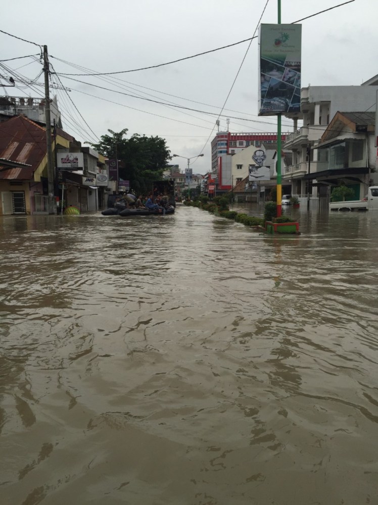 Down this street you can see the back of the police truck and a raft full of people being evacuated from the chest-deep water down the street.