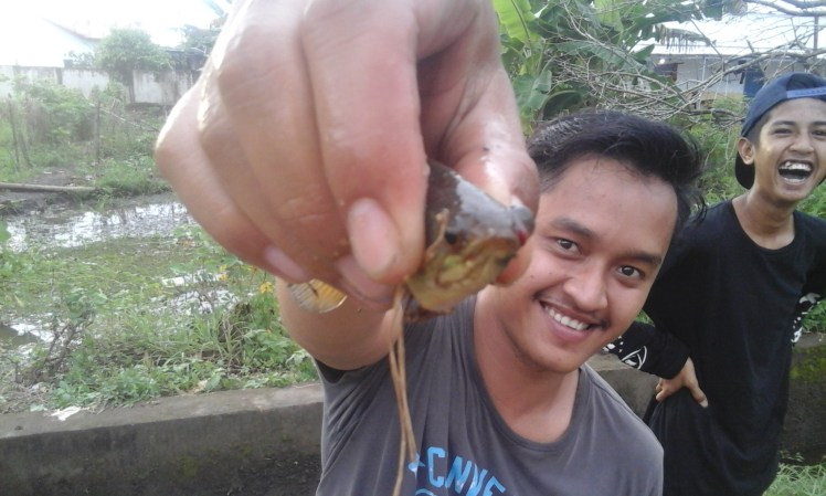 I didn't catch anything during my brief attempt at fishing, but Dian did. His cousin Andre is the one laughing in the background.